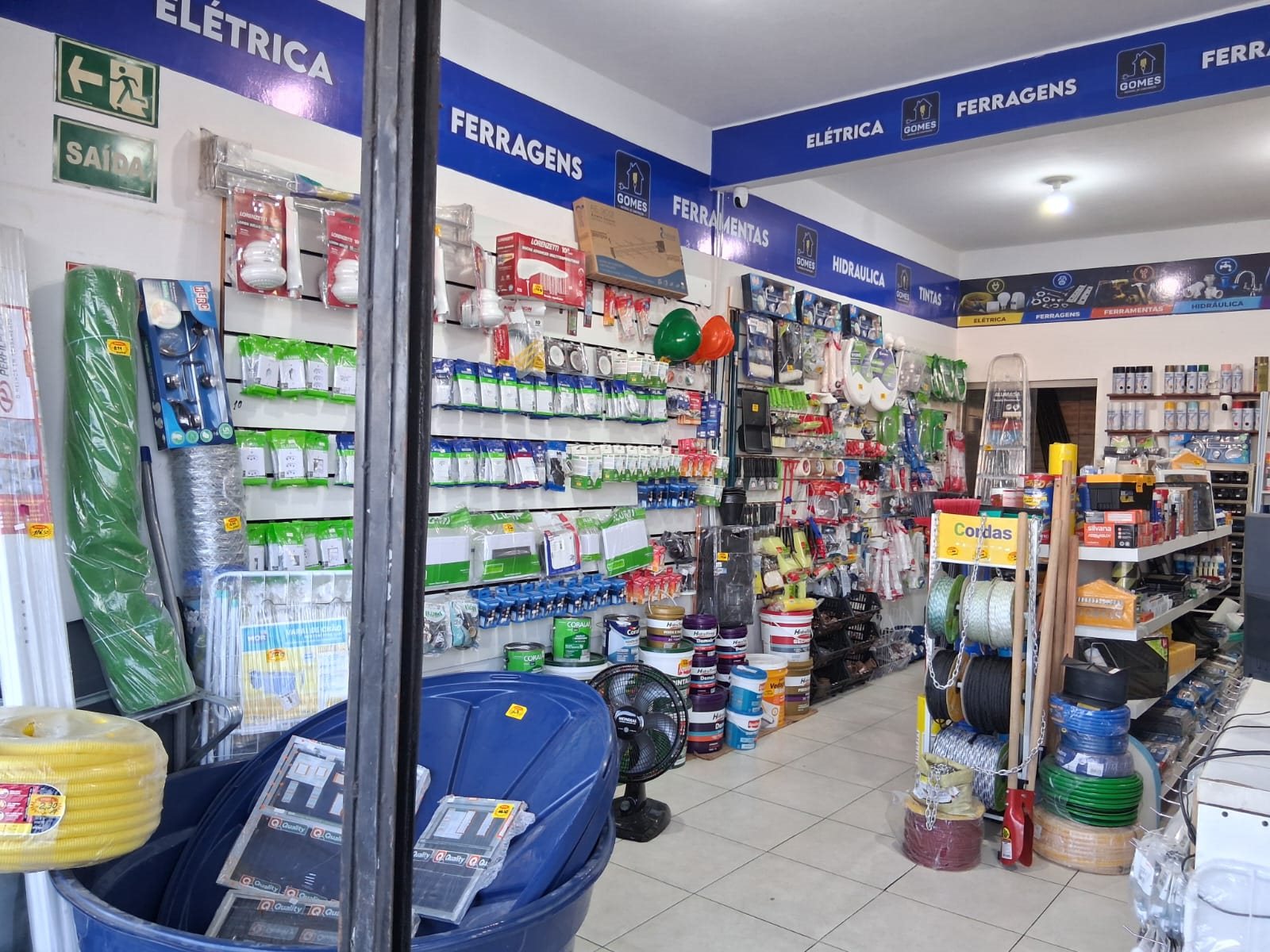 Interior da Gomes com ferramentas, materiais elétricos e hidráulicos nas prateleiras